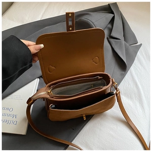 Macro detail of brown leather bag interior with multiple compartments and striped lining