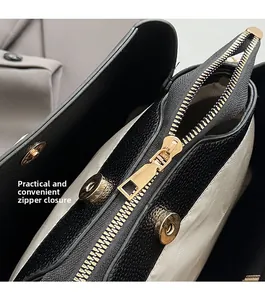 Close-up of litchi leather bag with gold zipper and magnetic buckle closure detail