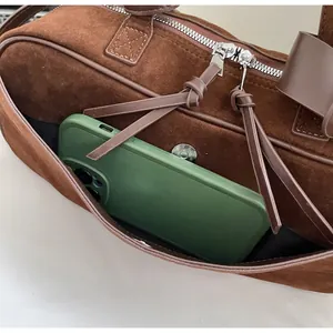 Detail of front slip pocket on brown matte bowling bag showing phone storage capacity