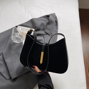 Schwarze Schultertasche aus Leder und Wildleder mit elegantem goldenem Metallanhänger