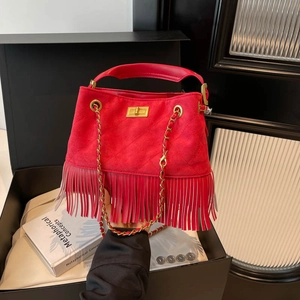 Red suede shoulder bag featuring long tassels, gold chain strap, and metallic turn-lock