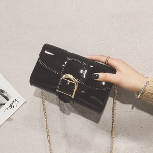 Sac bandoulière en cuir verni noir brillant avec boucle fer à cheval dorée et chaîne