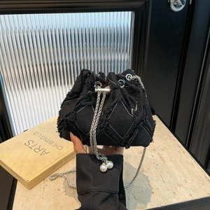 Black denim quilted drawstring bucket bag with silver chain and pearl charms