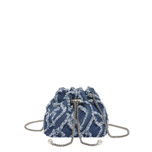 Blue denim bucket bag with quilted fringe texture, chain strap and pearl drawstring detail