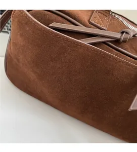 Detailed close-up of brown matte suede texture and stitching on the bowling shoulder bag