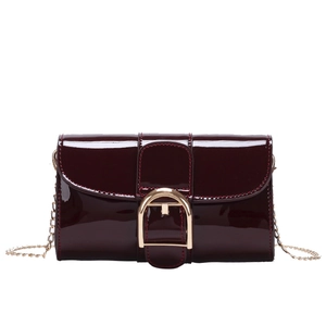 Sac à main en cuir verni bordeaux brillant avec boucle dorée en D et bandoulière