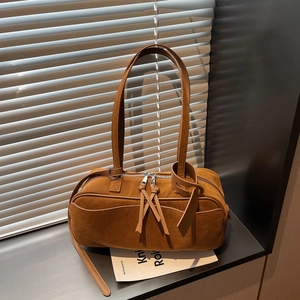 Detail of caramel suede hobo bag featuring long tassel zippers and silver hardware