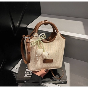 Detail der gewebten Beuteltasche mit braunem Lederbesatz und Tulpen-Perlenanhänger