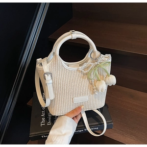 Detail der weißen geflochtenen Beuteltasche mit Perlen-Tulpen-Anhänger und Ledergriff
