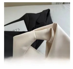 Detail view of the soft beige pleated dumpling bag featuring a wide knotted carry handle