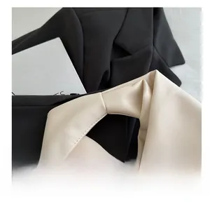 Close-up of contrast stitching and material details on a monochrome fashion handbag
