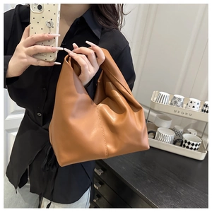 Detail of dark camel faux leather dumpling bag with textured pleated cloud design