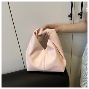 Detail of the pale pink knotted croissant bag with soft pleated vegan leather design