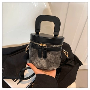 Details der zweifarbigen Beuteltasche mit Doppelreißverschluss und Lederriemen