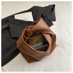 Close-up of brown PU leather dumpling bag showing large capacity and knotted handle detail