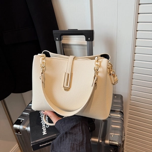 Chic off-white textured leather crossbody bag with gold buckle on silver luggage