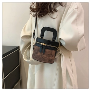 Detail der Vintage-Eimertasche mit zweifarbigem Design und goldenen Metallbeschlägen