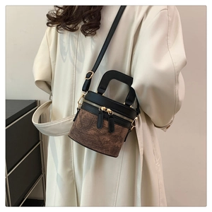 Detail der Vintage-Eimertasche aus schwarzem Leder und strukturiertem Marmorstoff