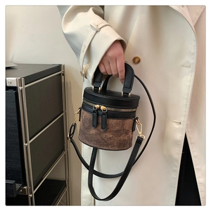 Detail der Vintage-Eimertasche mit schwarz-brauner Lederstruktur und Goldbeschlägen
