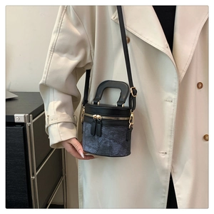 Detail der blauen Denim-Beuteltasche mit Blumenmuster, Lederbesatz und Goldbeschlägen