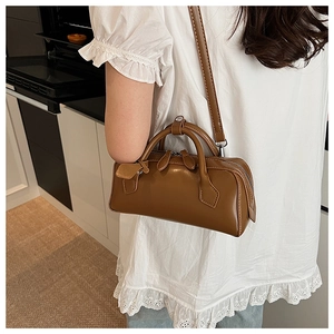 Side view of a vintage brown Boston bag featuring smooth leather and silver hardware detail