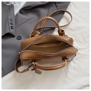 Interior view of caramel leather handbag showing main compartment and zipper pocket