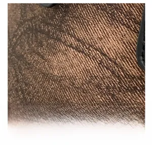 Detail einer braunen Eimer-Tasche mit Twill-Webmuster und präziser Nahtverarbeitung