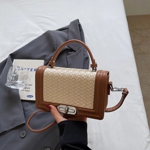 Chic beige woven crossbody bag with brown leather trim and silver twist lock detail