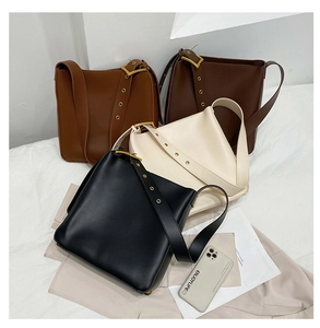 Detail of adjustable wide shoulder straps with gold buckles on minimalist bucket bags