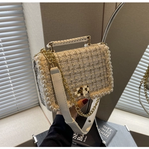 Detailed texture of tweed pearl chain bag with gold hardware and woven handle