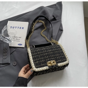 Detail of tweed shoulder bag featuring pearl trim and gold-tone twist-lock closure