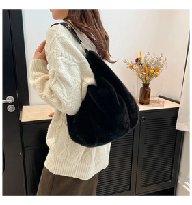 Détail du sac cabas en fausse fourrure noire avec anneau doré et bandoulière en cuir