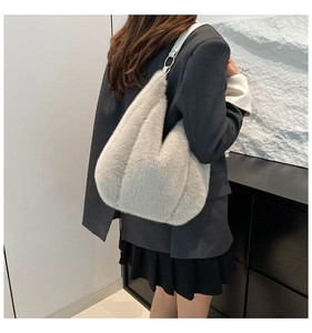 Detail view of the plush grey shoulder bag featuring soft faux fur and white leather strap