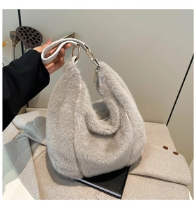 Detail of grey faux fur handbag showing white handles and gold metal rings