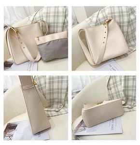 Detail view of large beige bucket bag with adjustable strap and grey inner pouch set