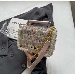 Close-up of multicolor tweed handbag featuring pearl trim edges and gold twist lock