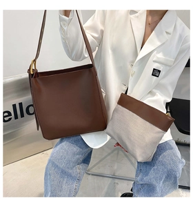 Detail of dark brown large capacity bucket bag with interior zipper pouch and wide strap