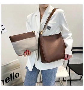 Detail of solid color bucket bag set featuring a wide strap and inner zippered pouch