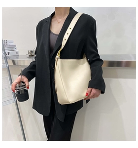 Detail of adjustable strap and gold buckle on a beige minimalist hobo shoulder bag