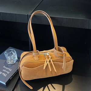 Minimalist tan suede shoulder bag with dual zipper design and front pocket detail