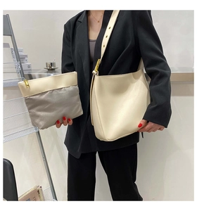 Detail of cream leather shoulder bag with gold eyelet strap and matching inner pouch