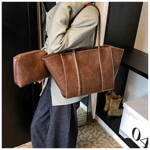Detail of vintage brown leather tote bag with a small pouch and embossed FASHION logo
