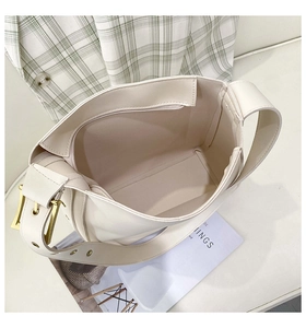 Detail view of cream leather bucket bag interior showing spacious lining and gold buckle