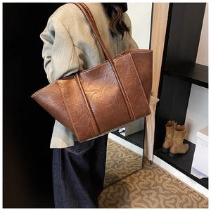 Close-up of brown PU leather tote bag featuring a vintage texture and FASHION embossed logo