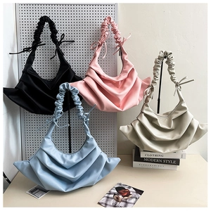 Detailed view of ruched shoulder bags in black, pink, blue, and cream faux leather