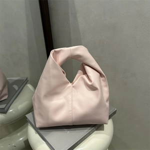 Minimalist light pink cloud bag with unique knot handle design and soft pleated leather