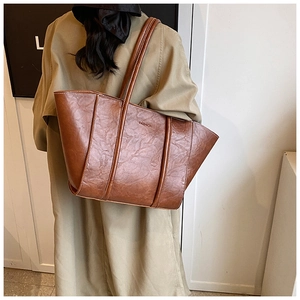 Close-up of vintage brown tote bag with wrinkled leather texture and fashion embossing
