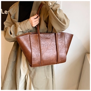 Close-up of vintage brown tote bag with textured faux leather and FASHION text detail