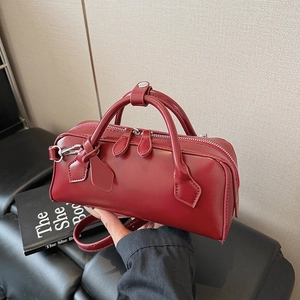 Deep red minimalist structured handbag with double top handles and adjustable strap