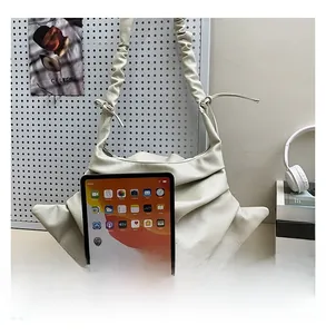 Detailed shot showing the large capacity of the pleated cloud bag compared to an iPad